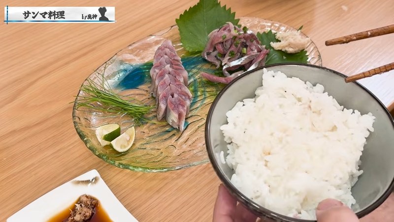 箸でサンマの刺身を持ち上げる布団ちゃん