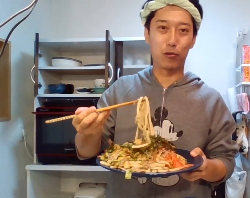 大人のスパイシー焼うどんを箸で持ち上げて食べる魔神