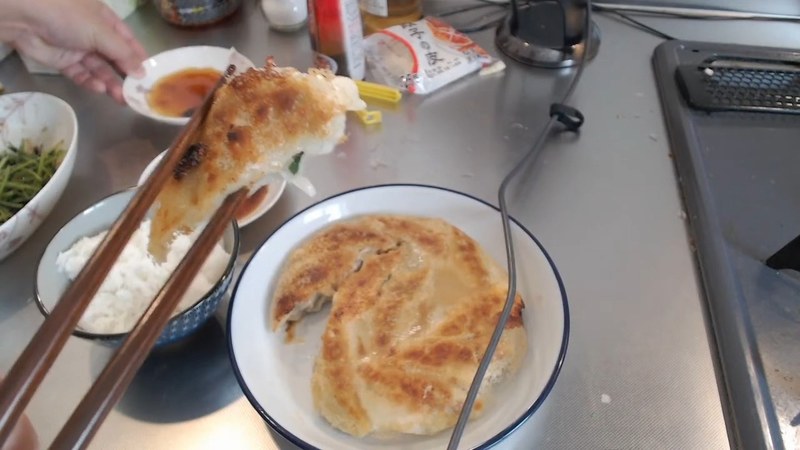 豚ひき肉の餃子を箸でつまむ布団ちゃん