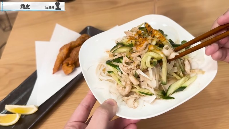 クニクニ鶏皮をキュウリと一緒に箸でつまむ