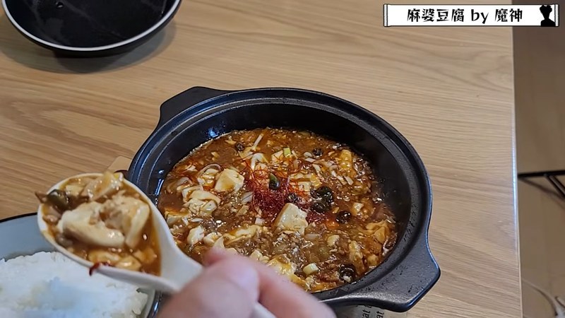土鍋の麻婆豆腐をご飯にかけてスプーンですくう魔神