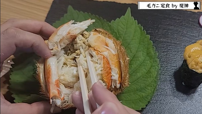 箸で甲羅から身をつまみ上げる場面