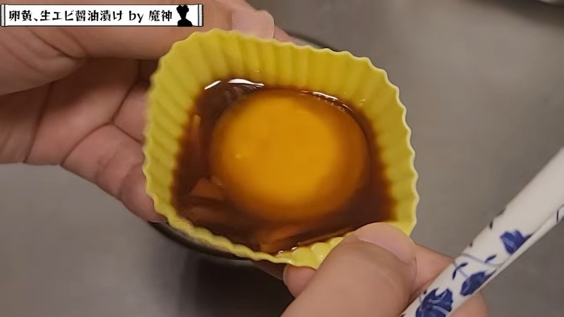 炊きたてご飯に黄身とエビ、生姜を盛りつける の画面