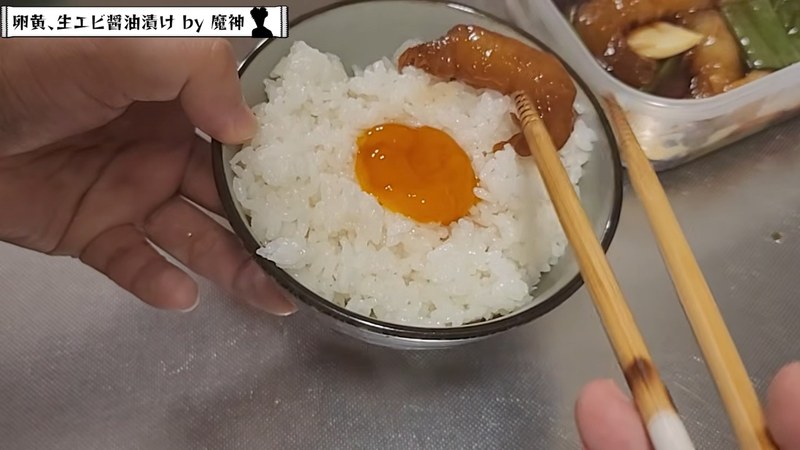 炊きたてご飯に黄身とエビ、生姜を盛りつける の画面
