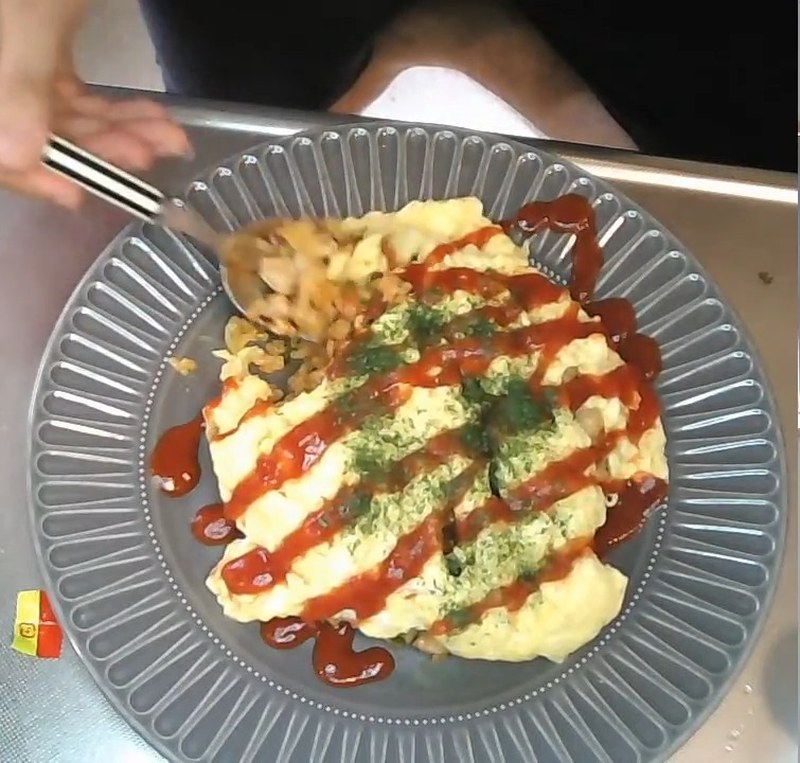 スプーンでオムライスをすくって食べているところ